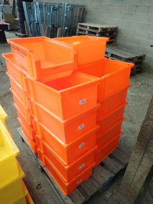 many orange boxes stacked on a pallet in a warehouse
