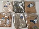 six pairs of men ' s pants in plastic bags on a table
