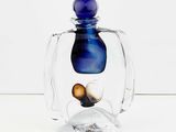 a glass jar with a blue lid and a coin inside of it