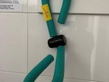 un crochet vert fixé au mur d'une salle de bains