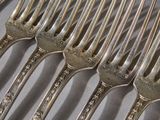 a lot of forks that are sitting on a plate