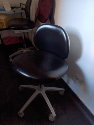 une photo d'une chaise de bureau noire dans un coin d'une pièce