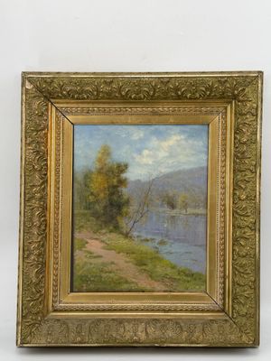 une peinture à l'huile représentant un paysage fluvial, dans un cadre doré sur fond blanc