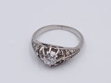 a close up of a diamond ring on a white surface