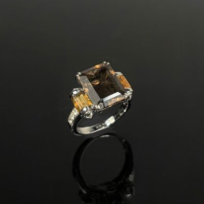une photo d'une bague sertie d'un quartz fumé et d'un saphir jaune
