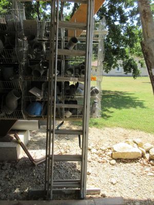 une échelle posée à côté d'une pile de casseroles et de poêles