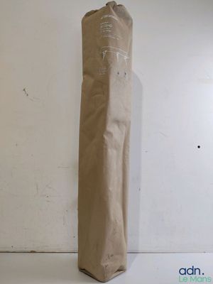un sac en papier brun posé par terre près d'un mur blanc