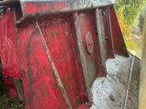 un tracteur rouge assis dans l'herbe