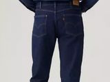 the back view of a man in a blue shirt and jeans