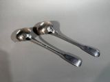 two spoons that are sitting on top of a table