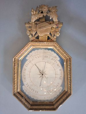 une horloge accrochée au mur, avec un cadre doré