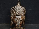 an image of a bronze statue of a buddha head on a black background