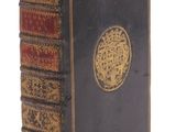 un vieux livre noir orné d'un médaillon doré sur la couverture