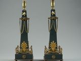 pair of black and gold candlesticks with chains on them