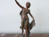 bronze statue of a woman holding a bird on a marble base