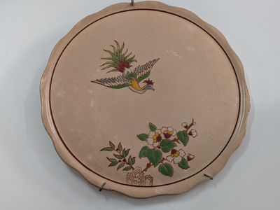 a picture of a decorative plate with a bird and flowers on it
