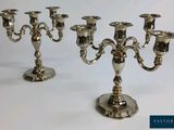 trois chandeliers en argent posés sur une table