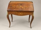 un bureau ancien orné d'un motif floral sur le plateau