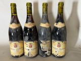 four bottles of wine are lined up on a table