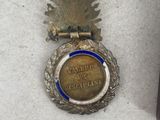 an old medal is sitting on a table next to a book