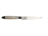 a knife that is sitting on a white surface
