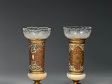 paire de vases ornés de motifs dorés et rouges, reposant sur des socles en marbre
