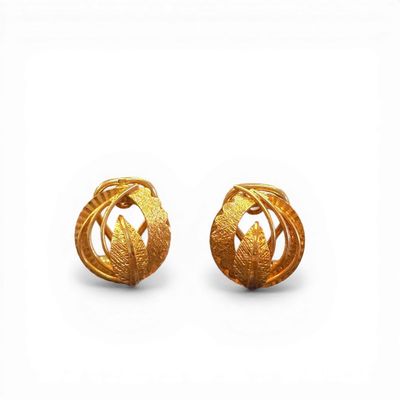 pair of gold earrings with leaves on them on a white background