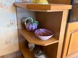 a corner shelf in the corner of a kitchen with vases on it