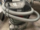 un aspirateur posé sur le sol de la pièce