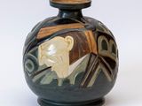 un vase noir sur lequel est représenté un homme