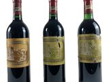 trois bouteilles de vin sont alignées sur une surface blanche