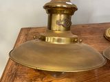 une paire de lampes en laiton posées sur une table en bois, avec un mur blanc en arrière-plan