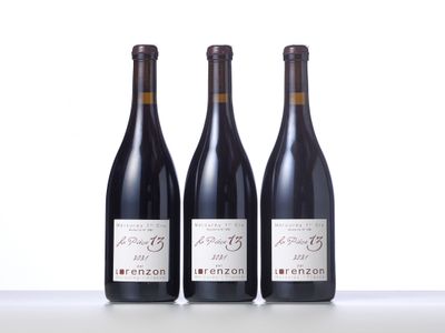 three bottles of wine are lined up on a table