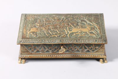 une vieille boîte en laiton ornée d'un motif représentant des animaux