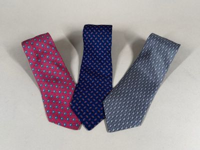 three ties are lined up in a row on a white surface