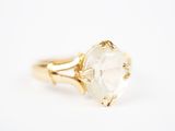 un gros plan d'une bague en or sertie d'un quartz transparent