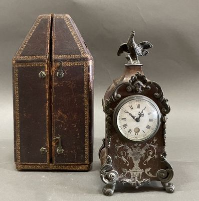 a small clock sitting next to a box with a bird on top of it