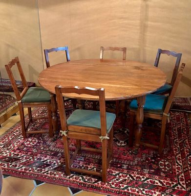 une table en bois avec quatre chaises et un tapis au sol