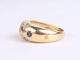 an image of a close up of a gold ring with blue and green stones