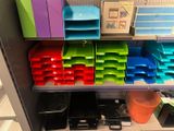 many different colored bins on a shelf in a room