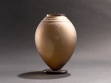 un vase posé sur un support sur une table