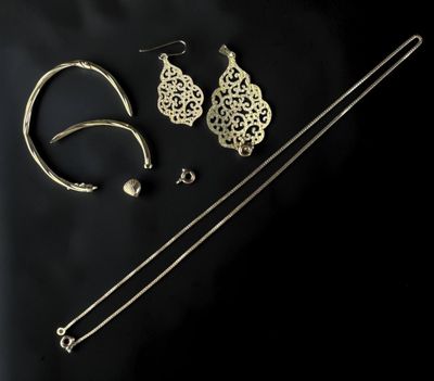 a close up of a pair of earrings and a necklace on a black background