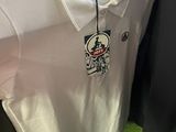 a white shirt hanging on a rack in a store