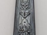 a silver spoon with a gold handle on a white wall