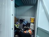 un petit débarras dont la porte donne sur une pièce remplie de bagages