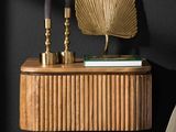 une étagère en bois sur laquelle sont posées deux bougies et un livre
