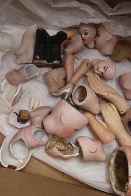 une boîte remplie de têtes de poupées et d'autres objets posée sur une table