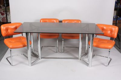 an image of a glass table with orange chairs and a white backdrop
