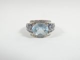 a white gold ring with a blue topaz and diamonds