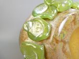 un gros plan d'un vase orné de motifs verts